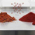 Close-up image comparing a mound of coarse natural red iron oxide pigment with a mound of pure, fine synthetic red iron oxide powder in a laboratory.
