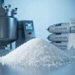 Mound of white Polyvinyl Alcohol PVA granular powder in an industrial laboratory setting for adhesive and coating manufacturing